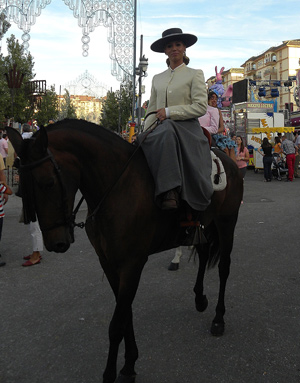 Ryttarinna i damsadel, elegant kldd i bl a sombrero.